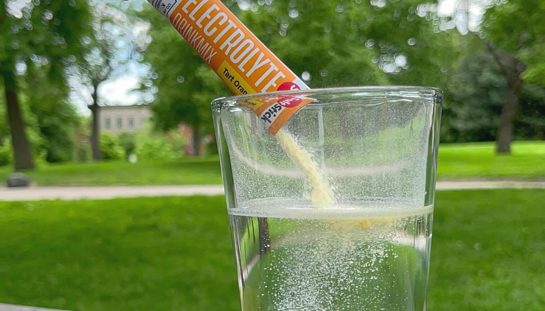 Orange DrinkMix being poured into a glass of water