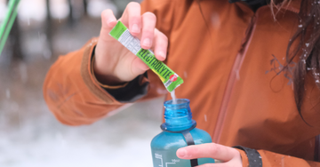 girl pouring drinkmix into bottle