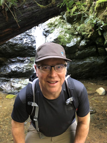 Mac with a backpack on a hike in nature.