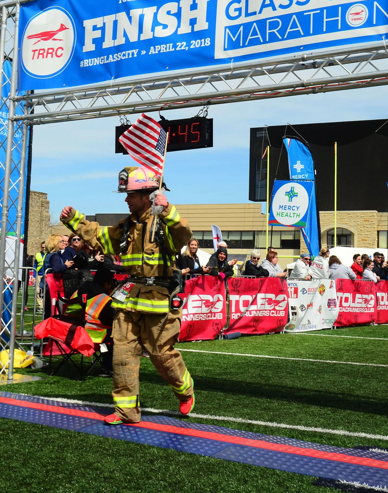 Firefighter crossing a marathon finish line.