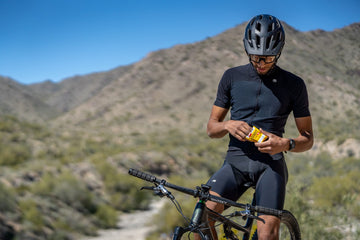 Mountain biker reaching into a packet of SaltStick FastChews electrolyte tablets
