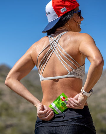 A runner smiling and holding a SaltStick Lemon-Lime FastChews packet.