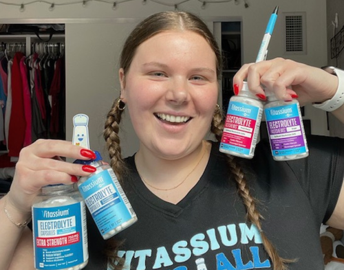 Person holding multiple bottles of Vitassium products.
