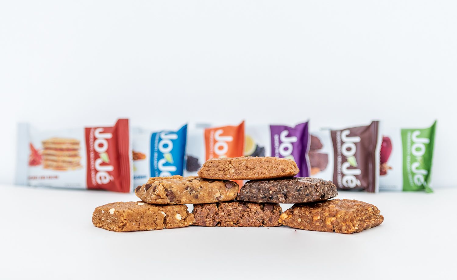 Six flavors of JoJe bars in their wrappers and also unwrapped.