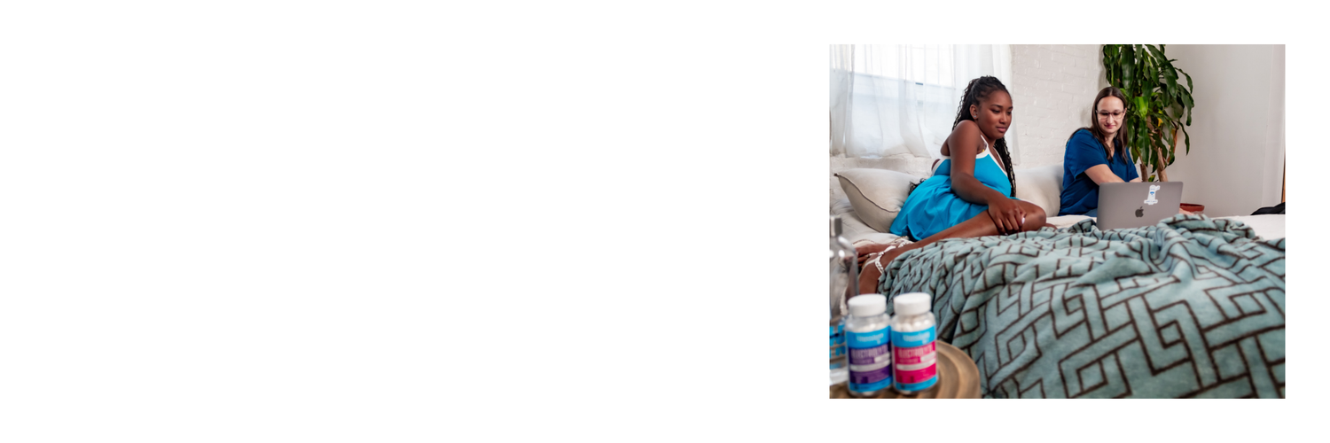 Two people sit on a bed with two bottles of Vitassium FastChews in the foreground.