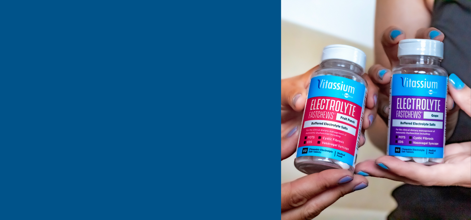 One pair of hands hold a bottle of Vitassium Fruit Punch FastChews and a second pair of hands hold a bottle of Grape FastChews
