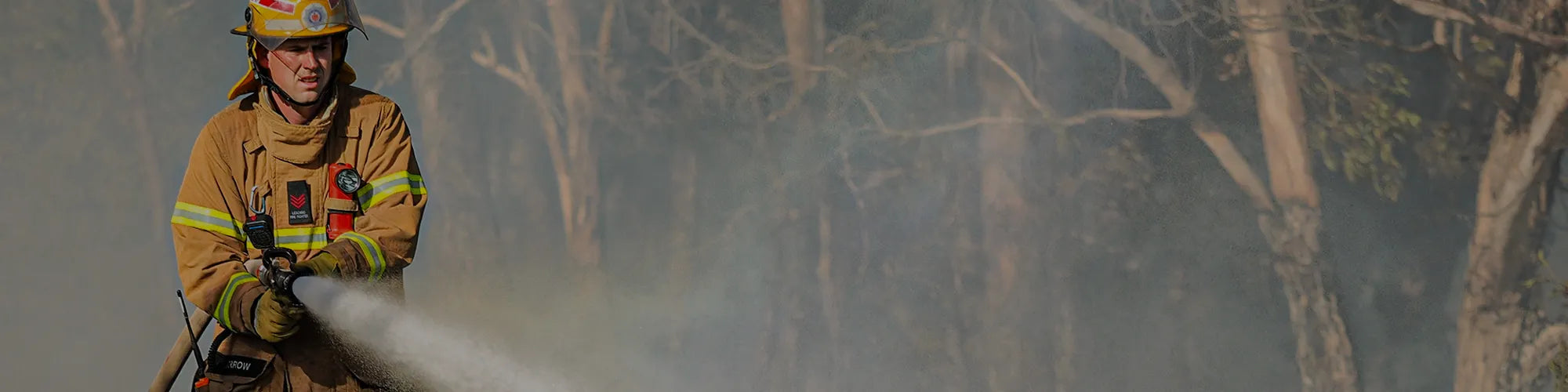 Firefighter with a hose in the forest.