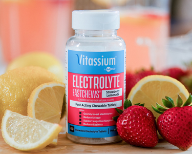 Vitassium by SaltStick Electrolyte FastChews in Strawberry Lemonade flavor, 60 fast-acting chewable tablets, shown beside fresh lemons and strawberries.