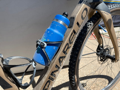 Blue water bottle branded with JoJé logo in bike bottle holder